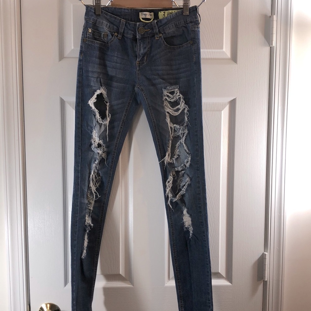 Blue denim distressed skinny leg jeans.